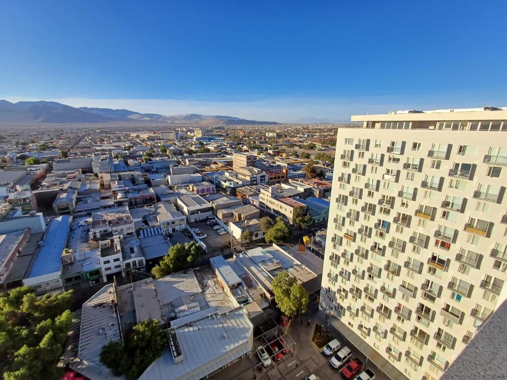 an aerial view of a city with a tall building at Departamento Central in Calama