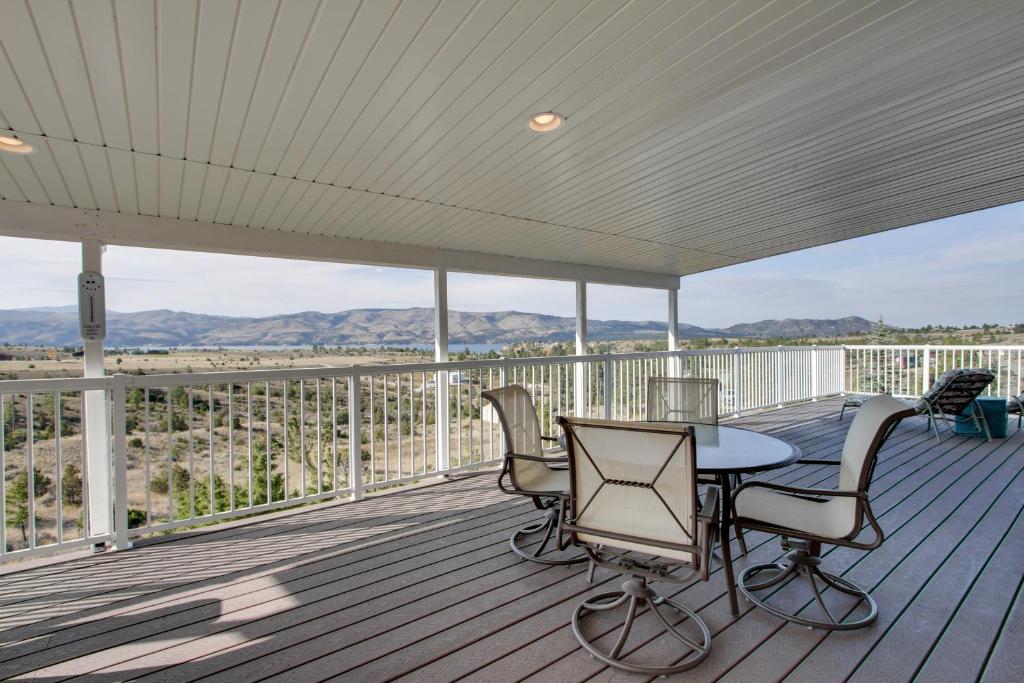 un patio con mesa y sillas en una terraza en Spacious Canyon Ferry Lake House with Bar and Views! en Helena