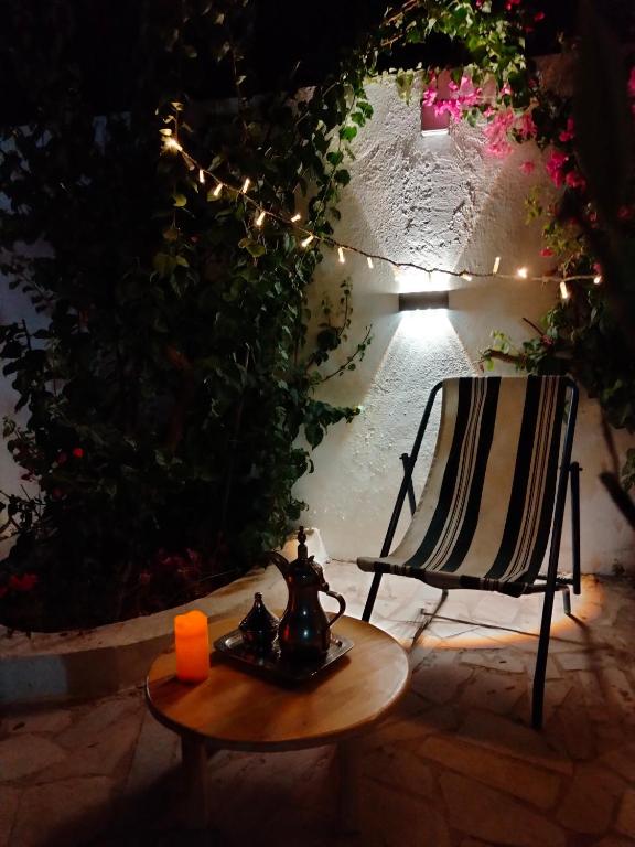 a chair and a tea pot on a table in a patio at Henchir ejdoud in Kairouan