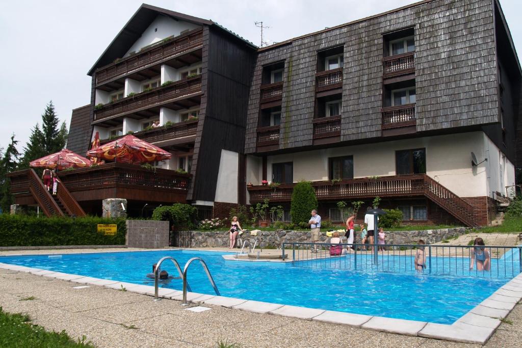 a swimming pool in front of a building at Hotel Pavla Vysočina in Nové Město na Moravě