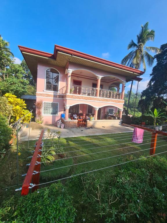 a house with a balcony and a yard at Rotunda Inn home stay in Pagadian