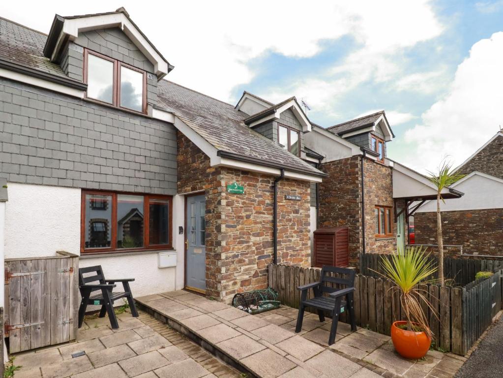 a brick house with a patio and a fence at Sunflower Cottage in Wadebridge