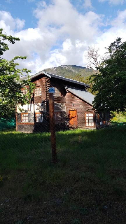 una vieja casa de madera en medio de un campo en Cabaña villa del lago en Lago Puelo