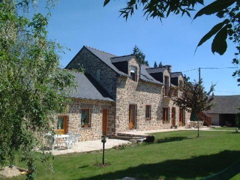 a large stone house with a lawn in front of it at Chambres D'Hôtes De Froulay in Couesmes-vauce