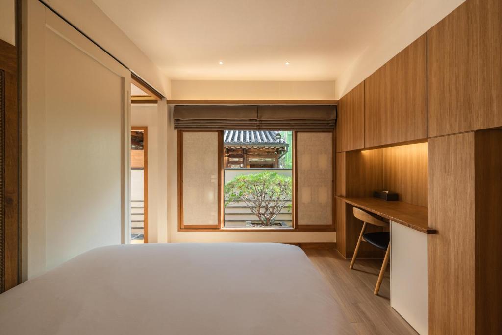 首爾的住宿－Luxury hanok with private bathtub - SN06，一间卧室设有一张大床和一个窗户。
