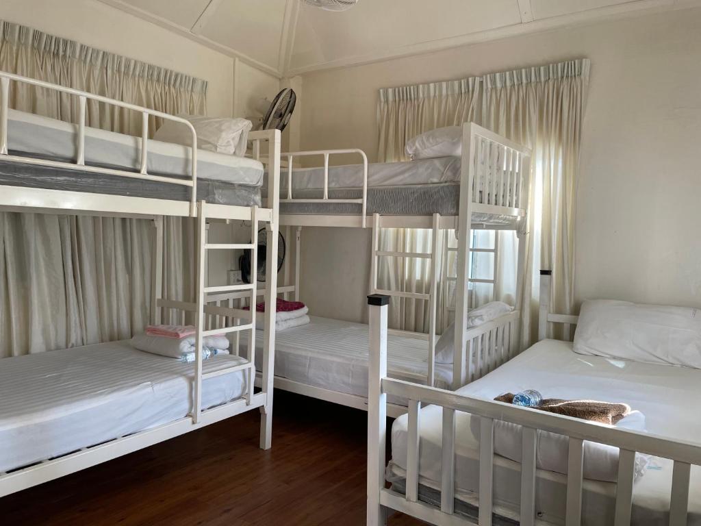 a room with three bunk beds in a room at Anna Hostel in Chaiyaphum in Ban Sieo