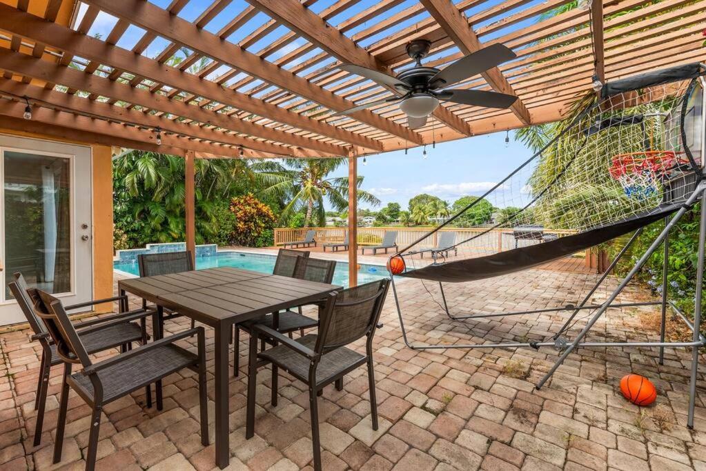 a patio with a table and chairs and a hammock at Modern spacious house with private pool and lake view in Fort Lauderdale
