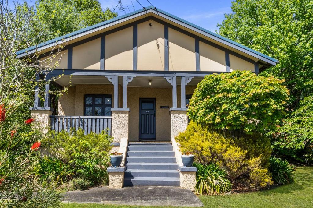 a house with a blue door and stairs at Brigalow Cottage in Leura