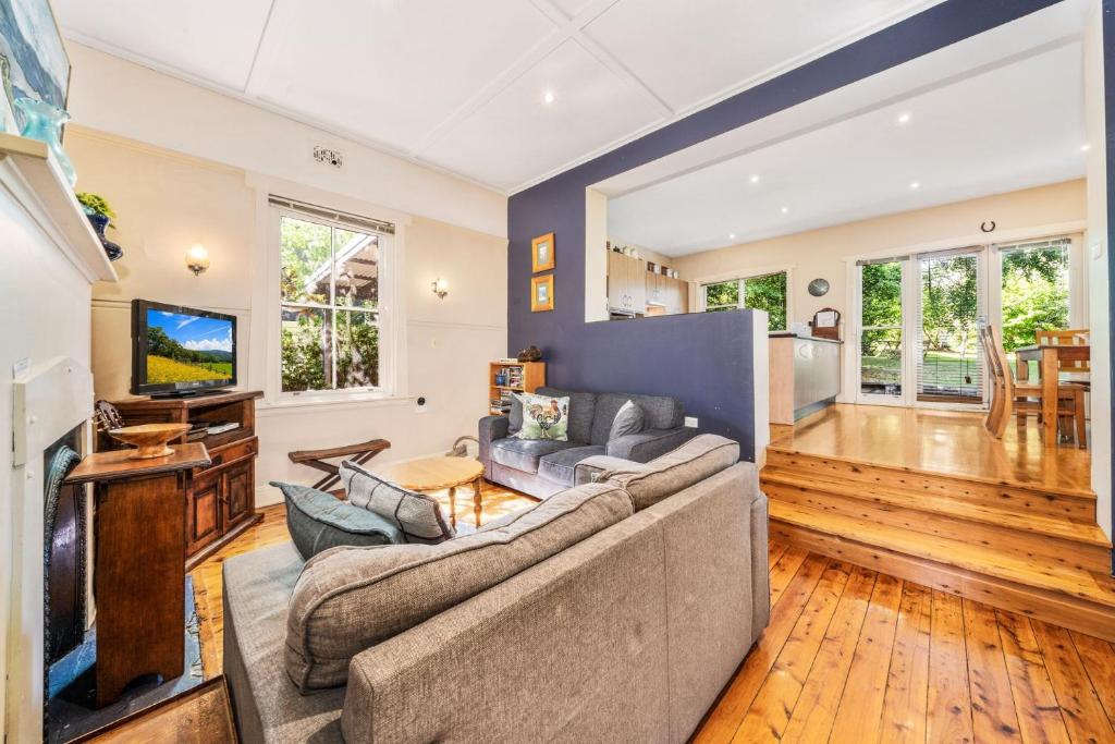a living room with a couch and a tv at Brigalow Cottage in Leura