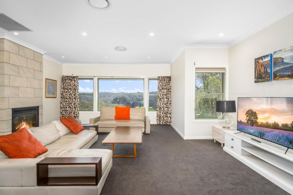a living room with a couch and a tv at Cliffnest House & Studio in Katoomba
