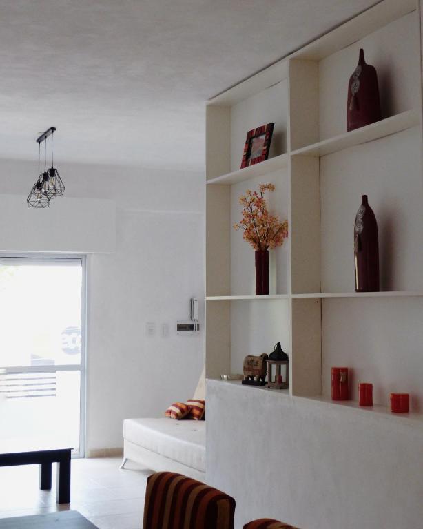 ein Wohnzimmer mit weißen Regalen und einem Sofa in der Unterkunft Habano Apart in Esquina