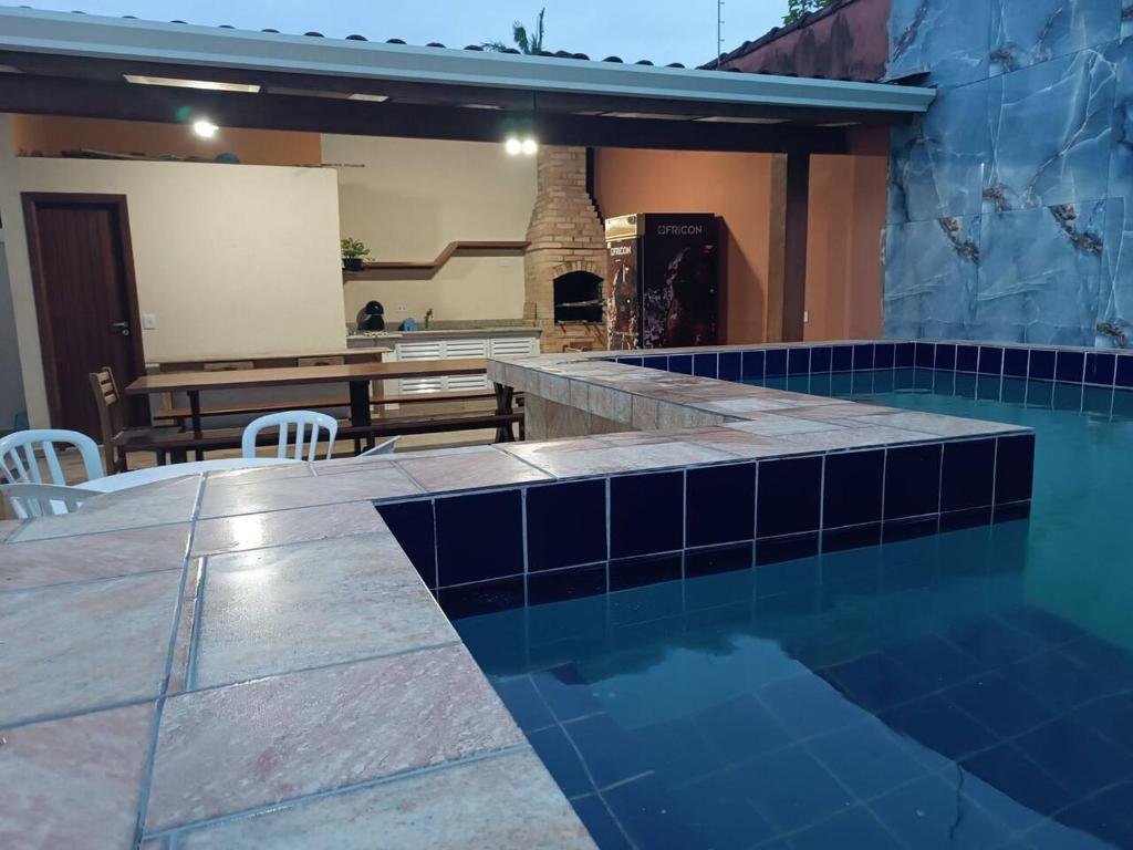 a swimming pool with a table and chairs in a house at Casa com Piscina e churrasqueira/ mar casado in Guarujá