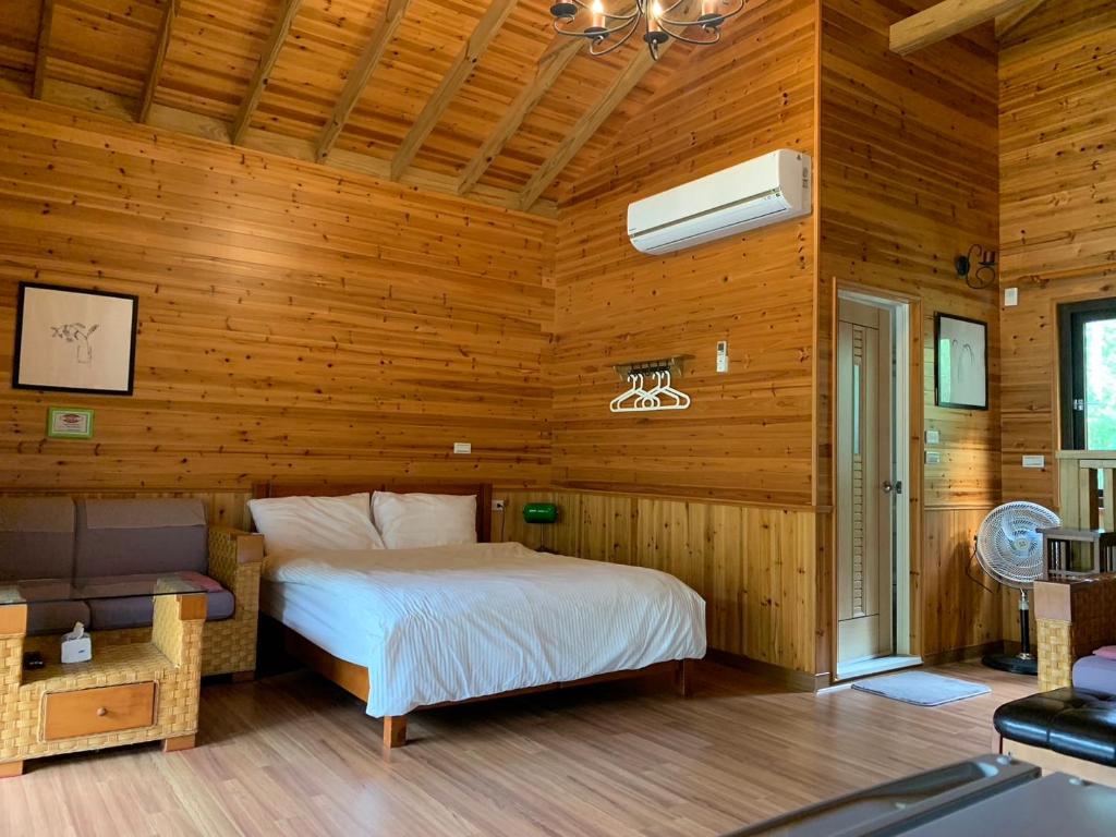 1 dormitorio con 1 cama en una habitación de madera en Cabin of Sun Moon Lake, en Yuchi