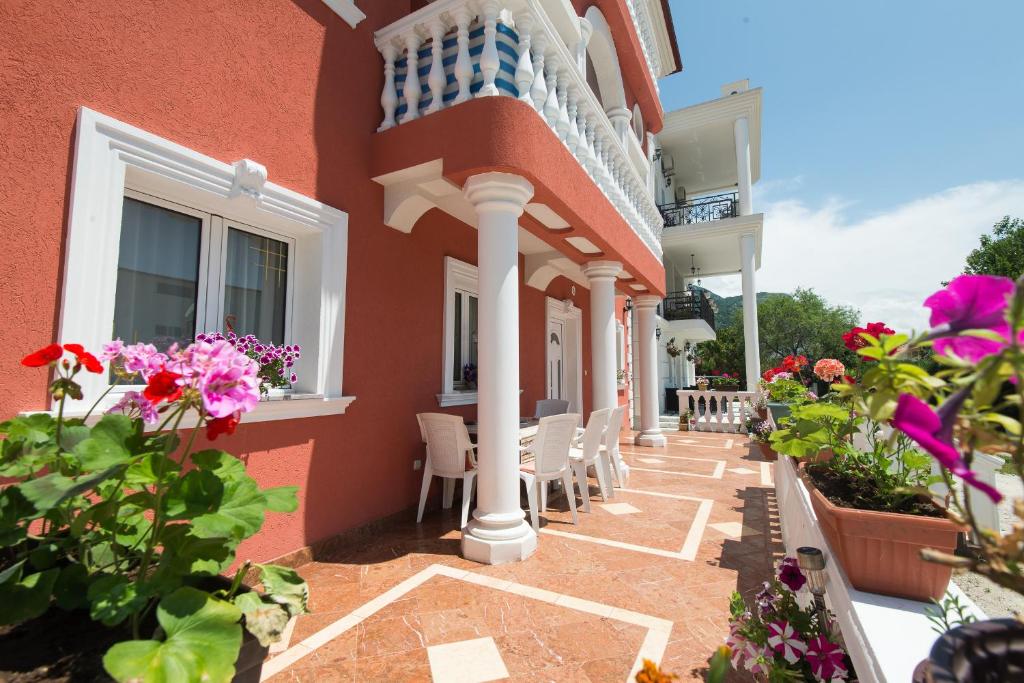 un edificio con sillas y flores en un patio en Hotel Wellness & Spa Angelo Gabriel, en Petrovac na Moru