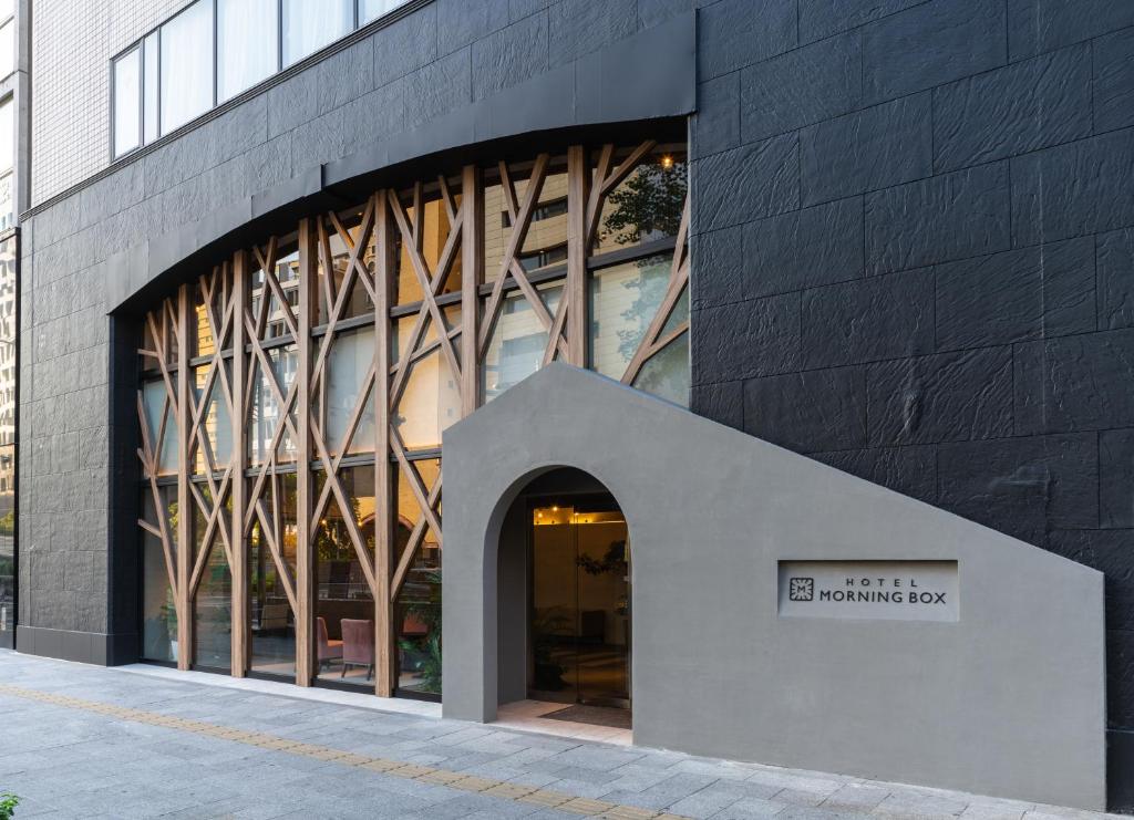 un edificio con una señal delante de él en Hotel Morning Box Osaka Shinsaibashi, en Osaka