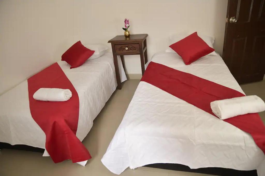 twee bedden in een kamer met rood en wit bij la casa del solo envigado in Envigado