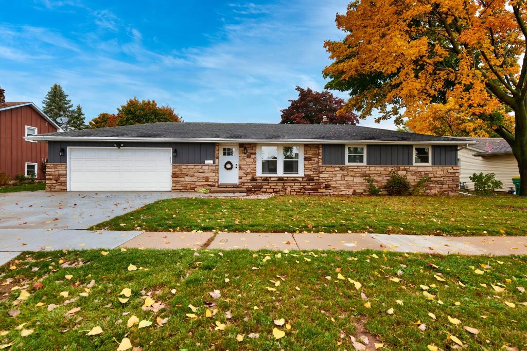 une maison en briques avec un garage blanc dans l'établissement Green Bay Stay, à Green Bay