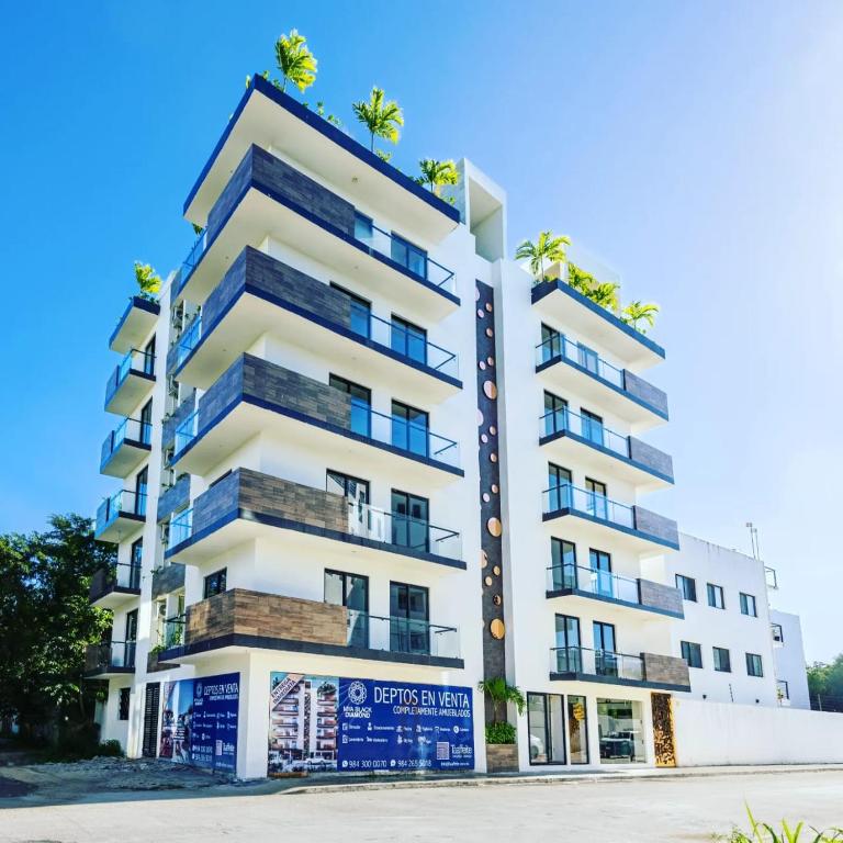 a white apartment building with blue balconies at Mya Black Diamond 202 in Playa del Carmen