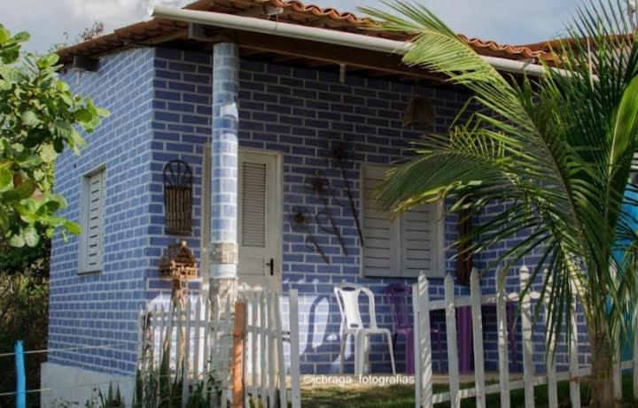 a blue brick house with a white fence in front of it at Mirante toca da raposa in Meruoca