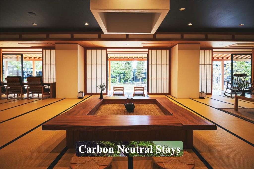 諏訪市にある寛ぎの諏訪の湯宿　萃sui‐諏訪湖の木製テーブルが備わる広い客室です。