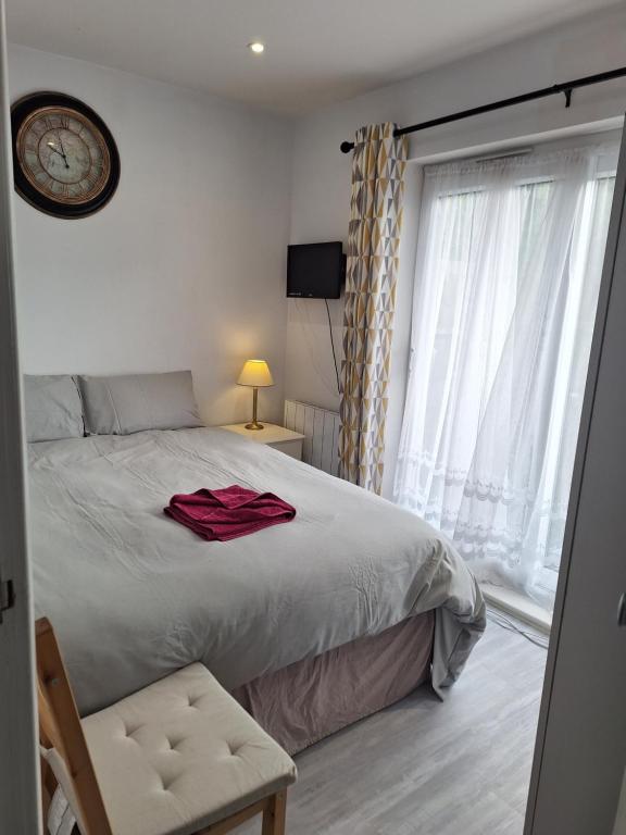 a bedroom with a large bed with a clock on the wall at Deluxe Single room only for one adult in Northolt