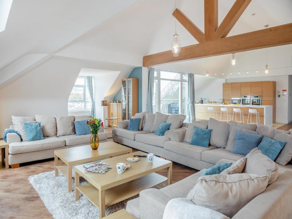 a living room with two couches and a table at The Penthouse in Morfa Nefyn
