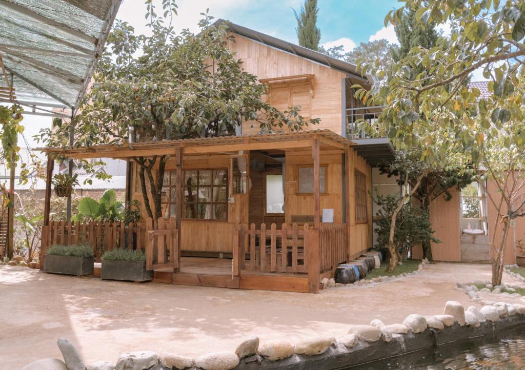 uma pequena casa de madeira com um alpendre em Mơ Garden Retreat DaLat em Da Lat