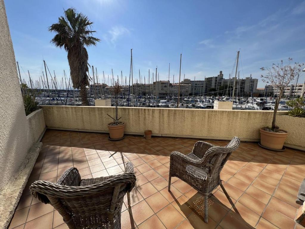 d'un balcon avec deux chaises et une vue sur le port. dans l'établissement Appartement rénové 1 chambre + cabine, parking privé, à 400m de la plage - FR-1-81-601, à Port-Leucate