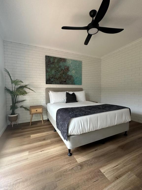 a bedroom with a bed and a ceiling fan at Burrum Tavern in Burrum Heads