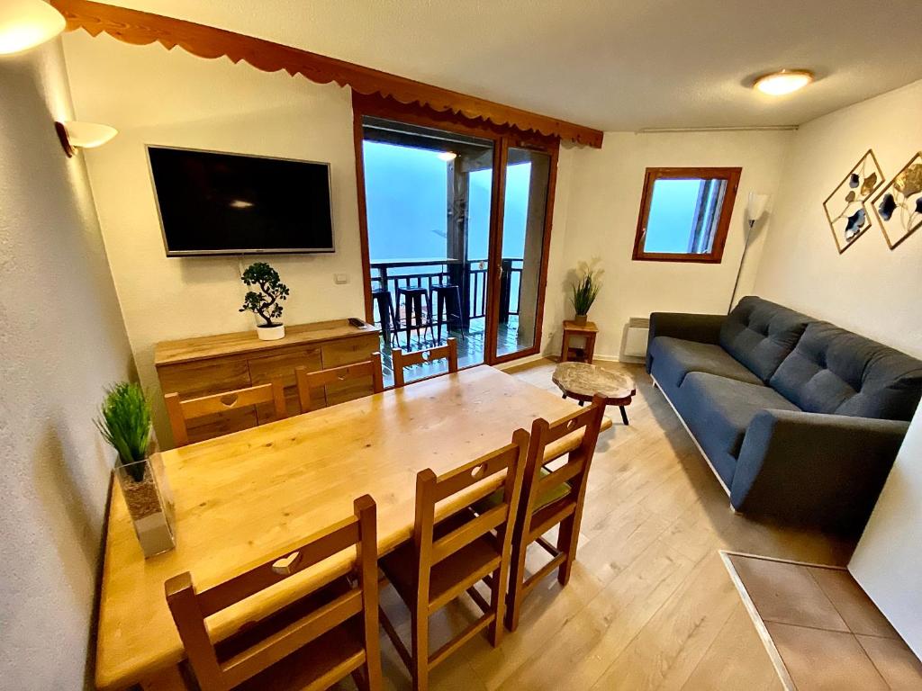 a living room with a table and a couch at Les Cristallines - Appartement Cosy in Orcières