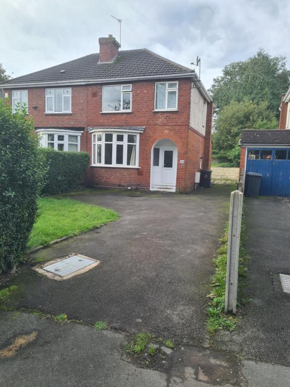 una casa de ladrillo rojo con una entrada delante de ella en L & J ESCAPES-4 BEDROOMs SUITABLE FOR CONTRACTORS AND FAMILIES- LARGE PRIVATE PARKING-10 MINUTES TO M6 JUNCTION 9 en Coseley