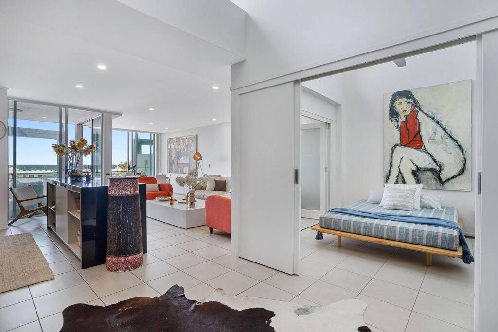 a room with a bed and a living room at Lookout 334 - Endless Ocean Views - Rooftop Spa in Kingscliff