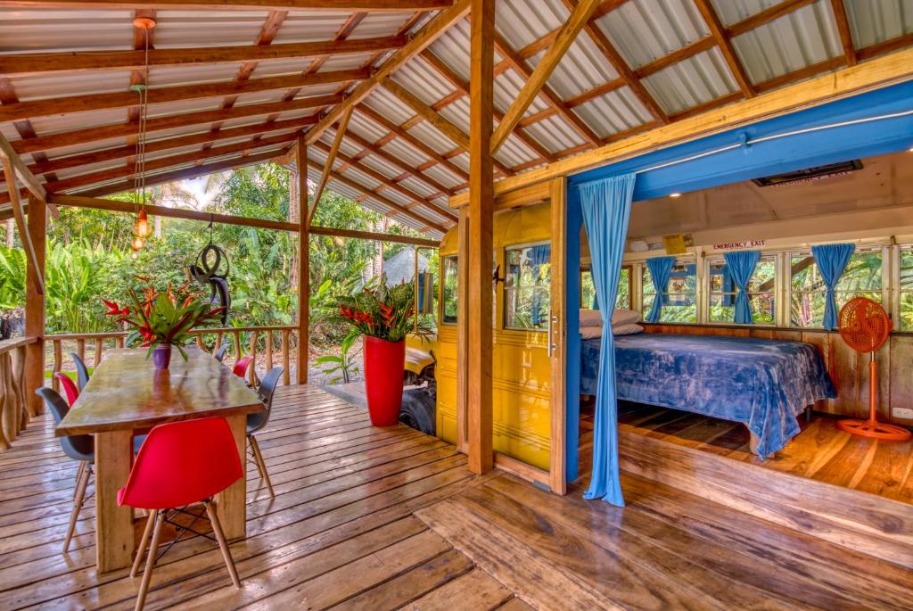 a master bedroom with a bed and a wooden deck at Tree House Beachfront Lodge in Puerto Viejo