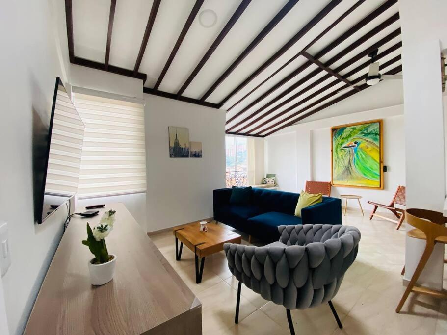 uma sala de estar com um sofá azul e uma mesa em Hermoso apartamento en Envigado em Envigado