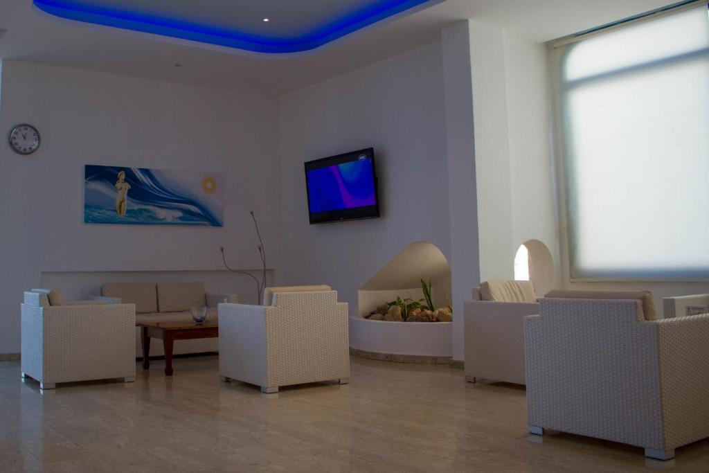 a living room with white chairs and a blue ceiling at Anonymous Beach Hotel (Adults 16+) in Ayia Napa