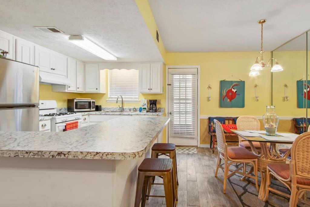 a kitchen with a counter and a table with chairs at Kimberly Villa in Panama City Beach