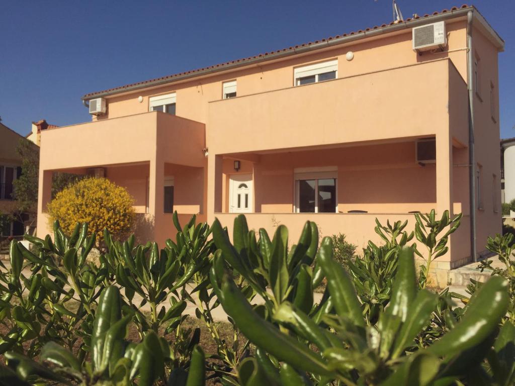 a house with a hedge in front of it at Sunny Rock Volme Apartments in Banjole
