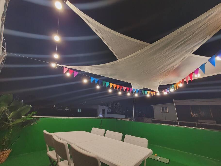 a white table and chairs in a room with lights at Reve Guwol in Incheon