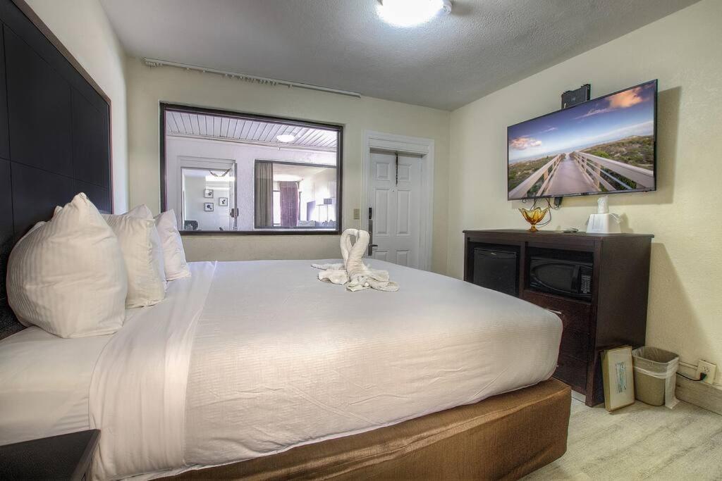 1 dormitorio con 1 cama blanca grande y TV de pantalla plana en *King Bed Aprt*120, en Daytona Beach
