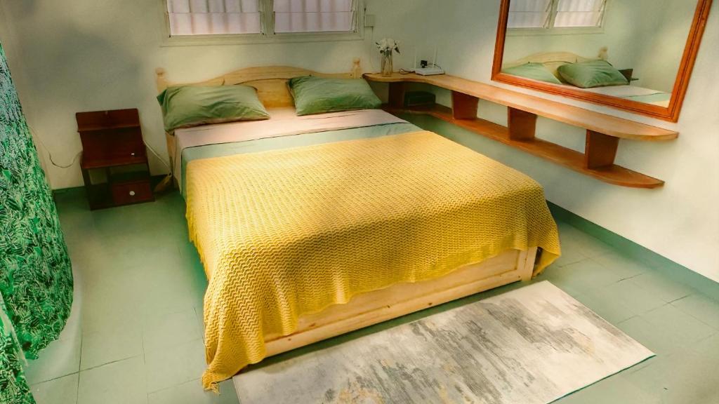 a bedroom with a bed with a yellow blanket on it at Kerith Lodge in Port Vila