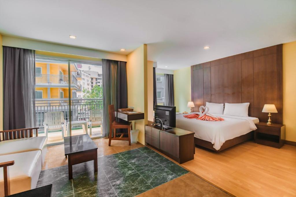 Cette chambre d'hôtel comprend un lit et un balcon. dans l'établissement Bauman Residence Patong, Phuket, à Patong Beach