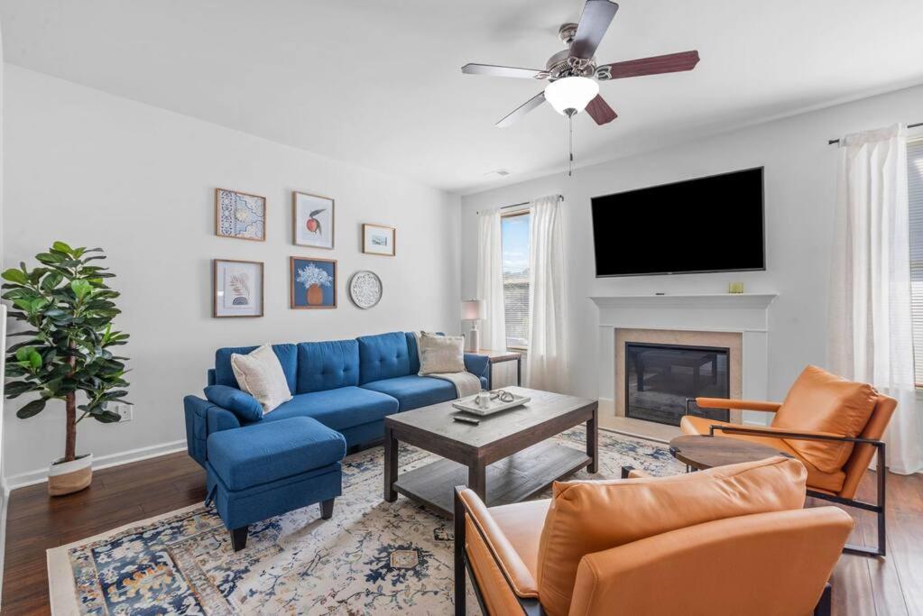 a living room with a blue couch and a fireplace at Quiet Oasis in Lawrenceville