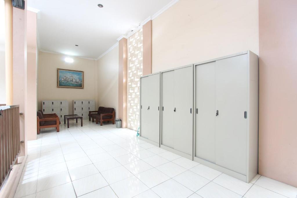 a hallway with lockers and a room with a chair at SPOT ON 93245 Guet House Mulia Dua Syariah in Klaten