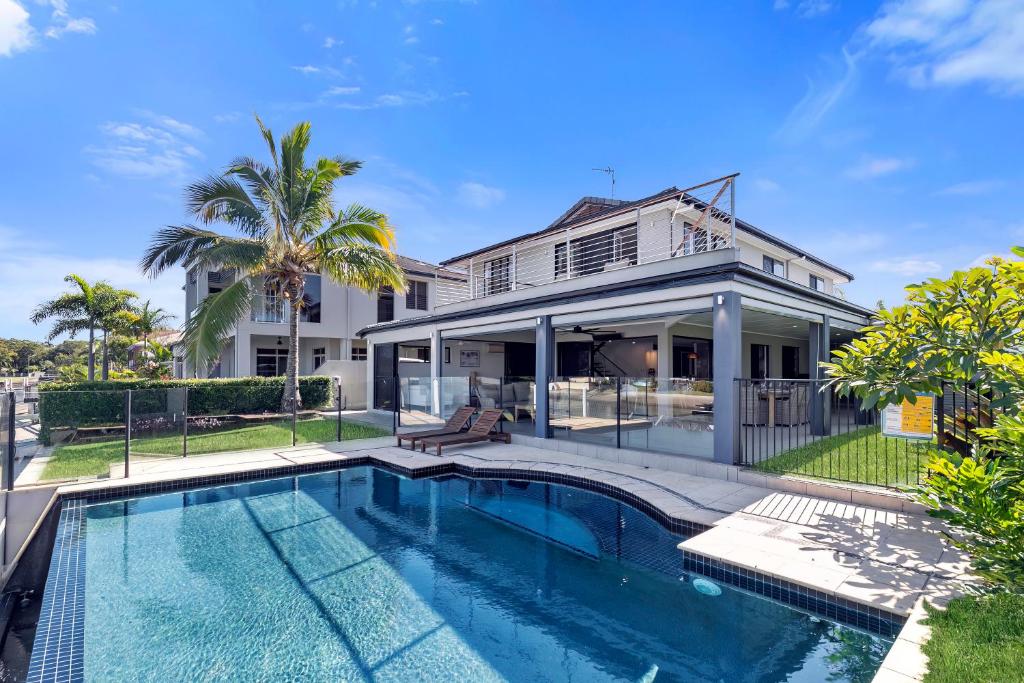 a house with a swimming pool in front of a house at YALLA24-Luxury Resort Style Home in Mooloolaba