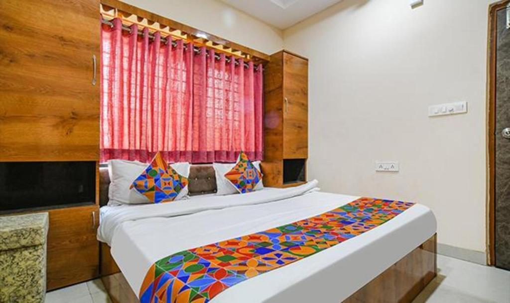 a bedroom with a large bed with a window at FabHotel Royal Palace in Indore