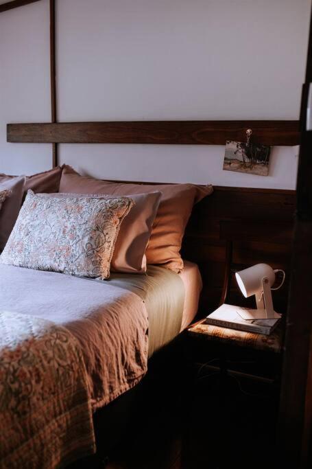 a bedroom with a bed with a wooden head board at Cottage 3 - The Row in Forest Grove