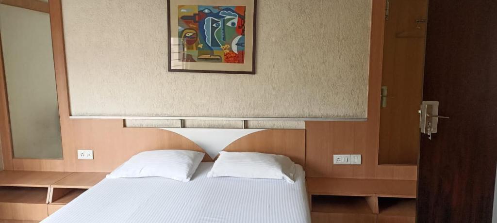 um quarto com uma cama com uma fotografia por cima em Ballygunj Guest House em Calcutá