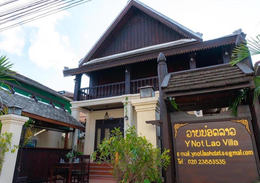 a building with a sign in front of it at Y Not Lao Villa in Luang Prabang
