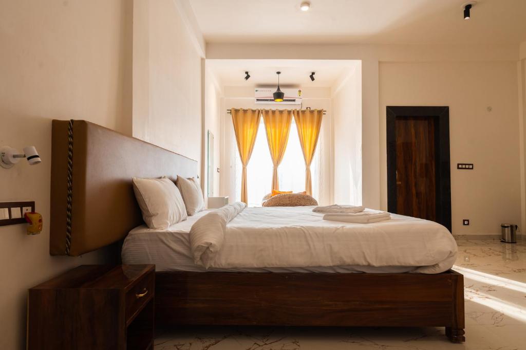 a bedroom with a large bed with a window at The Kaziranga Address in Kāziranga