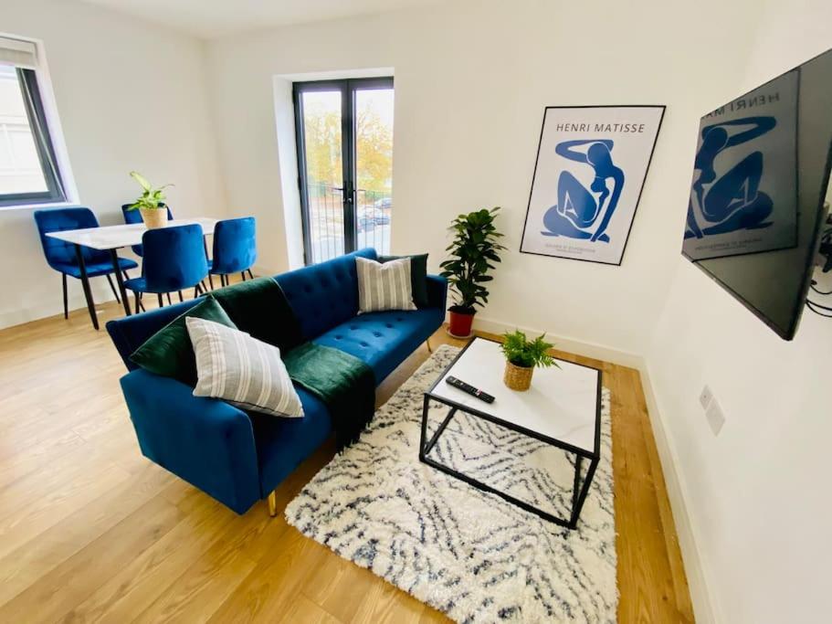 a living room with a blue couch and a table at Apartment 12 Contractors & Professionals 